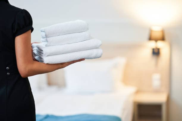 Hostel staff using tablet to scan bed QR codes for cleaning status